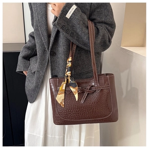 Dettaglio borsa shopper marrone coccodrillo con sciarpa di seta decorativa sul manico