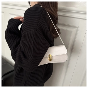 Détail du sac porté épaule blanc à motif crocodile avec fermoir rotatif en métal doré