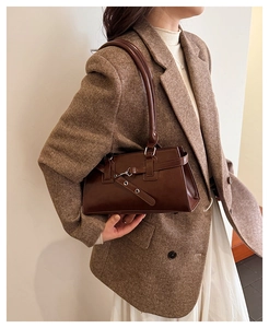 Close-up of a dark brown vintage rectangular shoulder bag with metal buckle detail