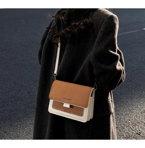 Outdoor shot of the tri-color flap bag with accordion sides and adjustable strap