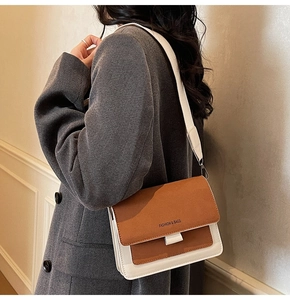 Close-up of a two-tone frosted crossbody bag with wide strap on a model shoulder
