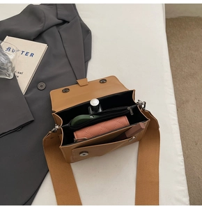 Detail of caramel crossbody bag interior with a wide canvas strap and daily essentials