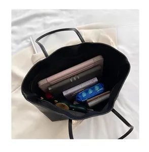 Top-down view of a black tote bag showing spacious interior with tablet and daily essentials
