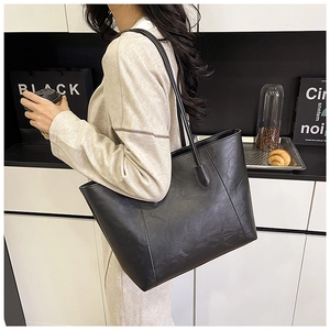 Macro shot of textured black PU leather tote bag in a modern urban lifestyle setting