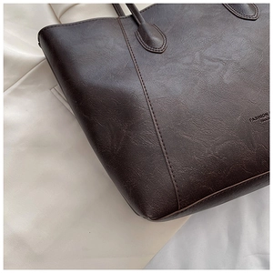Macro shot of dark brown tote bag showing retro leather texture and fashion embossing