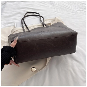 Detailed close-up of dark brown tote bag with premium pebble grain leather texture