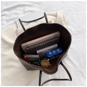 Deep brown oversized tote bag interior showing capacity for tablet, wallet, and essentials