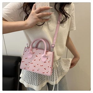Détail du mini sac cabas rose avec imprimé cerises, poignées et bandoulière réglable