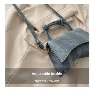 Detail showing the adjustable gold metal buckle on a blue denim texture shoulder bag