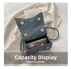 Internal view of denim crossbody bag showing storage capacity for phone and cosmetics