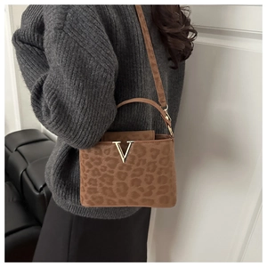 Gros plan du sac à main léopard avec boucle dorée en V et texture en fausse fourrure