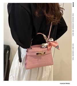 Pink crocodile-embossed handbag with gold twist lock and chic orange floral silk scarf