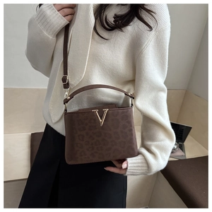 Détail du sac à main léopard avec boucle en métal V dorée et texture en daim doux