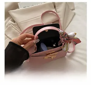 Pink croc-embossed handbag showing internal capacity for cosmetics and accessories