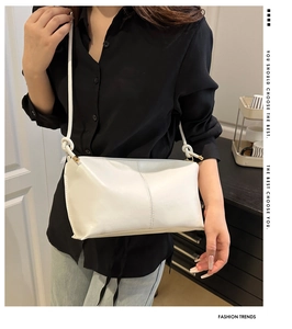 Minimalist white leather crossbody bag with knot shoulder strap and gold hardware