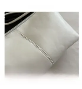 Gros plan détaillé de la double couture sur la surface du sac à main en cuir blanc