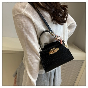 Chic black crocodile embossed handbag detail with elegant floral silk scarf and gold clasp