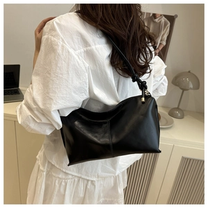 Sac à bandoulière noir tendance avec détail de nœud élégant sur la sangle en intérieur moderne