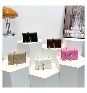 Quilted crossbody bags in five colors with metal S-logo and fringe tassels on display