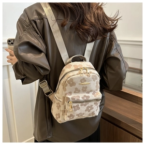 Mini backpack with daisy floral print shown on a model's back in a stylish interior