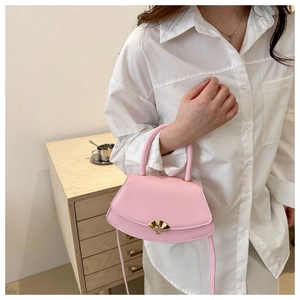 Gros plan du sac à bandoulière rose avec un fermoir en métal doré en forme d'éventail