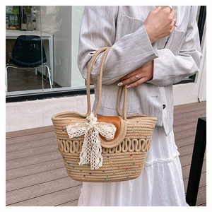 Détail du sac seau tissé avec pois colorés et nœud en dentelle blanche élégant