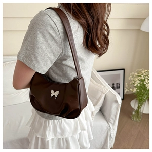 Détail du sac à bandoulière marron plissé avec un fermoir papillon en métal argenté