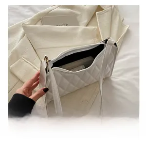 Détail de l'intérieur d'un sac à bandoulière matelassé blanc montrant l'espace de rangement