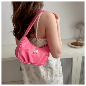 Détail du sac hobo plissé rose avec un charmant papillon en métal argenté décoratif