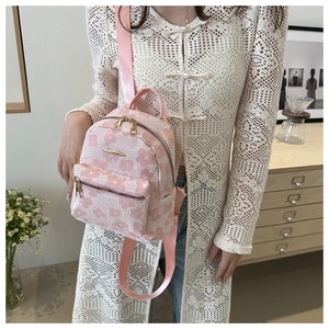 Close-up of pink floral jacquard mini backpack featuring golden metal dual zippers