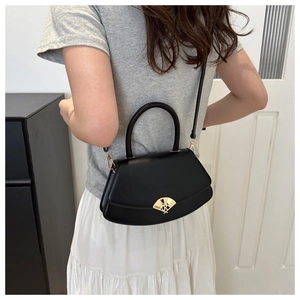 Détail du sac à main en cuir noir avec une boucle métallique dorée élégante en forme d'éventail