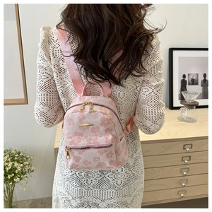 Rosafarbener Rucksack mit Blumenmuster, goldenen Reißverschlüssen und Trägern