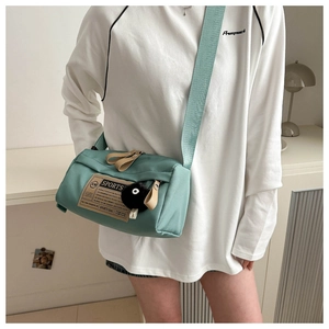 Detail of mint green nylon crossbody bag with wide strap and sports fabric patch