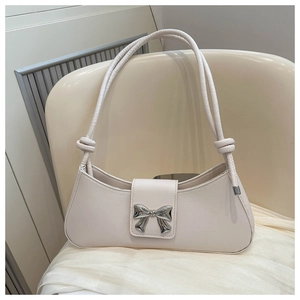 Detailed macro view of the cream white baguette bag with a silver metal bow buckle