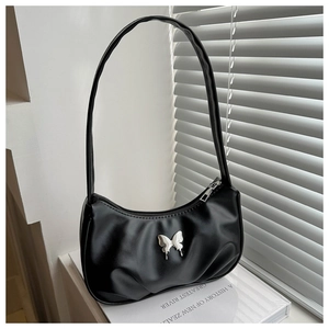 Détail du sac baguette en cuir mat noir avec ornement de papillon en métal argenté