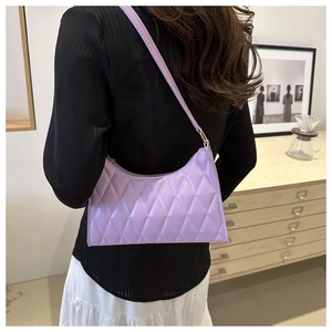 Vue détaillée du sac sous l'aisselle matelassé lilas brillant porté par un mannequin