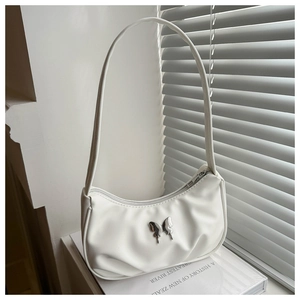 Détail d'un sac sous le bras demi-lune blanc avec une boucle papillon en métal argenté