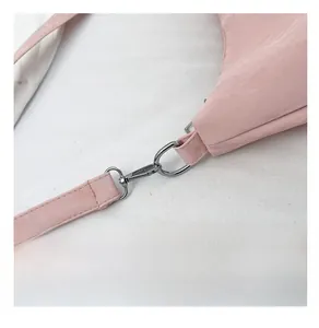 Dettaglio della fibbia in metallo argento e del cinturino in pelle rosa della borsa