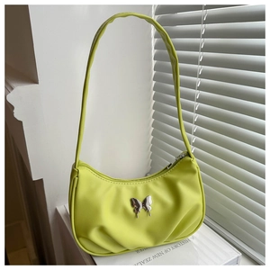 Détail du sac bandoulière vert citron avec ornement papillon argenté et zip