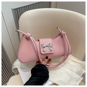 Detailed shot of pink baguette bag featuring silver bow buckle and twisted rope strap