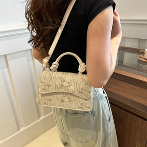 Straw crossbody bag with floral embroidery and braided handle in creamy white finish