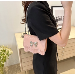 Detailaufnahme der rosa Tasche mit Marmormuster, Schleife und silberner Kette