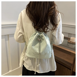 Minzgrüne Eimertasche mit Kordelzug, Metallschmetterling und weißen Perlen am Modell
