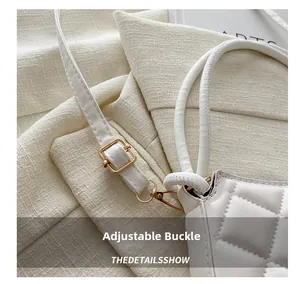 Détail de la boucle dorée réglable et de la bandoulière en similicuir blanc matelassé