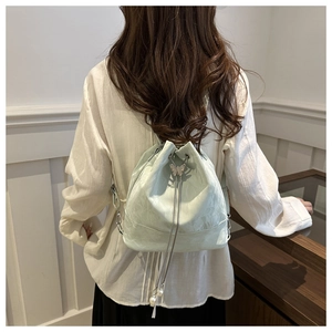 Nahaufnahme mintgrüner Eimer-Rucksack mit Schmetterlingsschnalle und Perlendetails