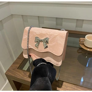 Detailansicht der rosa Umhängetasche mit Schmetterlingsschnalle und silberner Kette