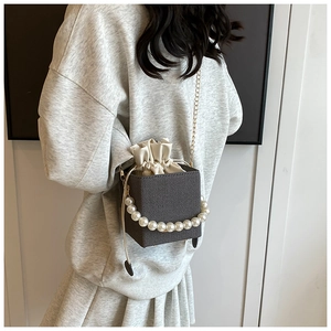 Dark grey beaded bucket bag with cream drawstring pouch and elegant pearl handle