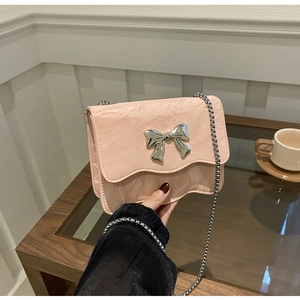 Detail der hellrosa Mini-Tasche mit silberner Schmetterlingsschnalle und Kette
