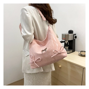 Borsa hobo rosa con fiocchi decorativi e un ciondolo a farfalla argentato raffinato