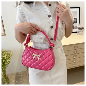 Détail du sac croissant matelassé fuchsia avec fermoir papillon doré et anse nouée